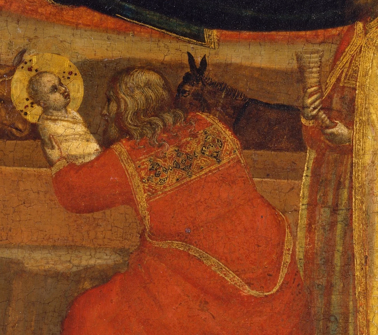 The old king holds the child as carefully as something that might break.