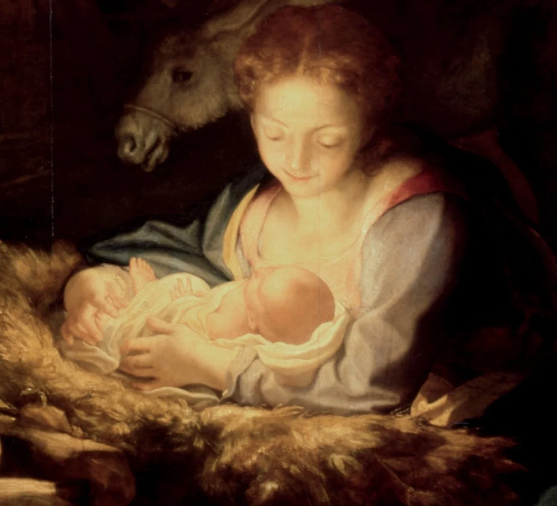Mary bends over the child. She is lit most brightly of all, and she alone does not blink.