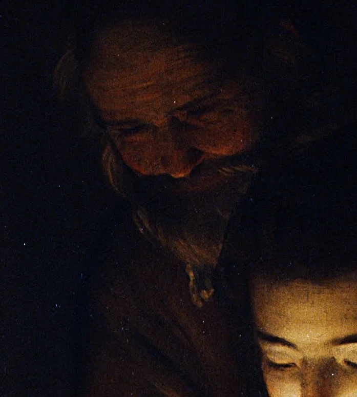 Joseph stands behind Mary, almost swallowed by the dark. The light reaches him last.