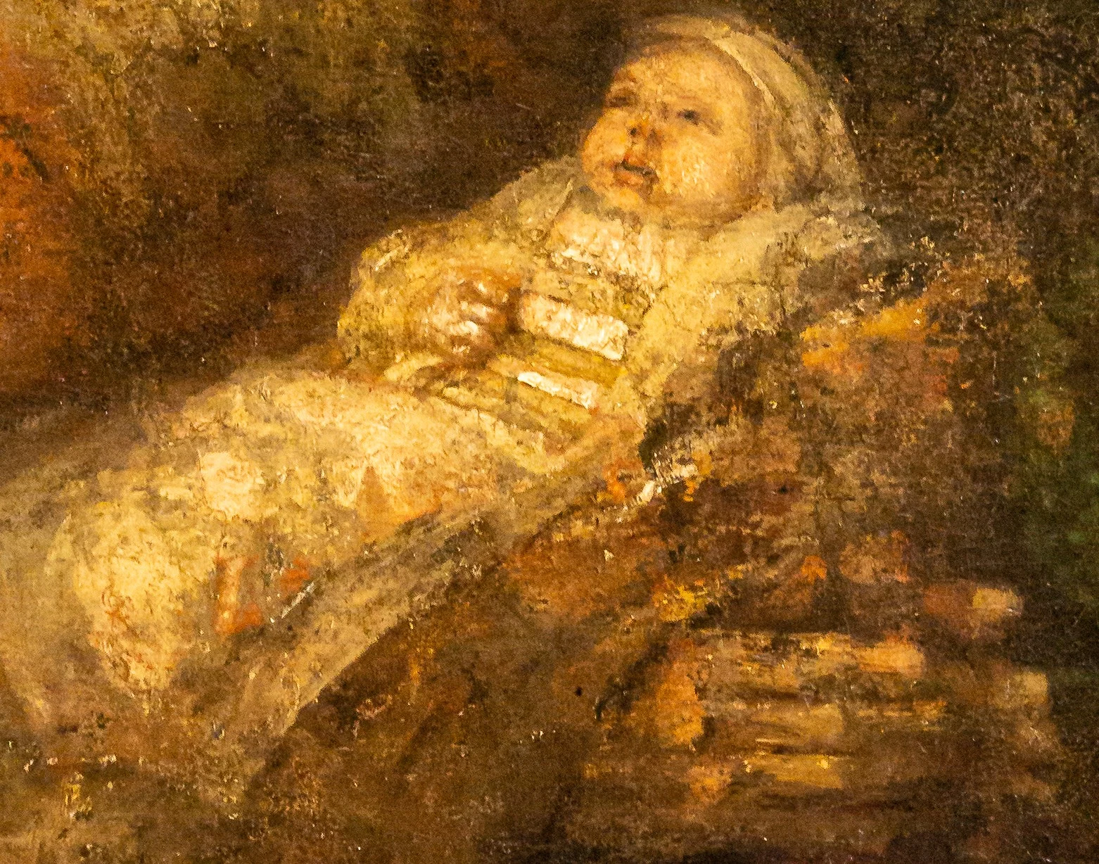 The child lies on the old hands as on a table.